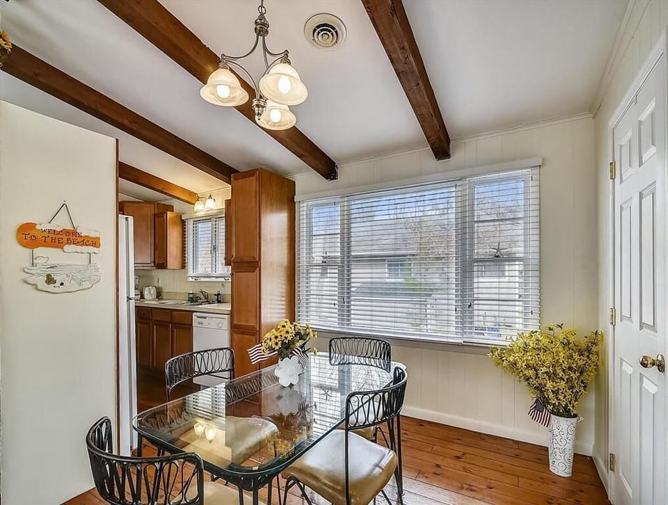 This dining space seamlessly connects to the kitchen, adorned with beautiful wooden beams and a glass table perfect for breakfasts and evening meals.