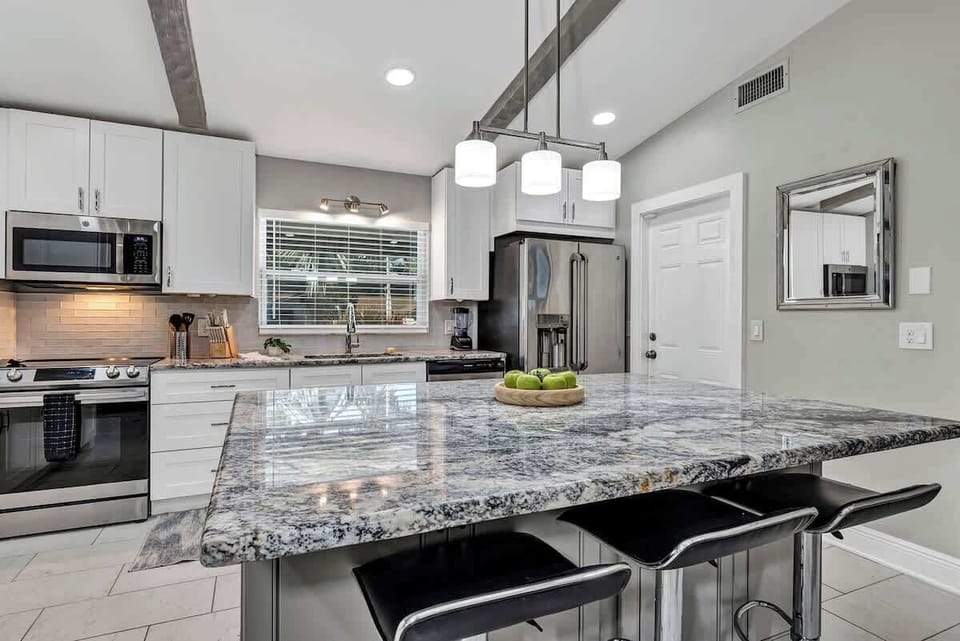 Spacious and elegant full kitchen! Large french door refrigerator, pots, pans, silverware, cooking utensils, blender, air fryer, insta pot, drip coffee machine, Keurig coffee machine, 3 comfortable bar stools around spacious island.