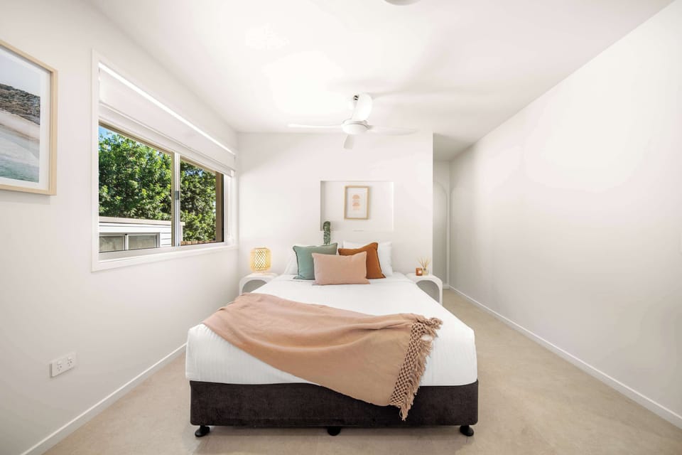 Master bedroom features a king bed and calming styling