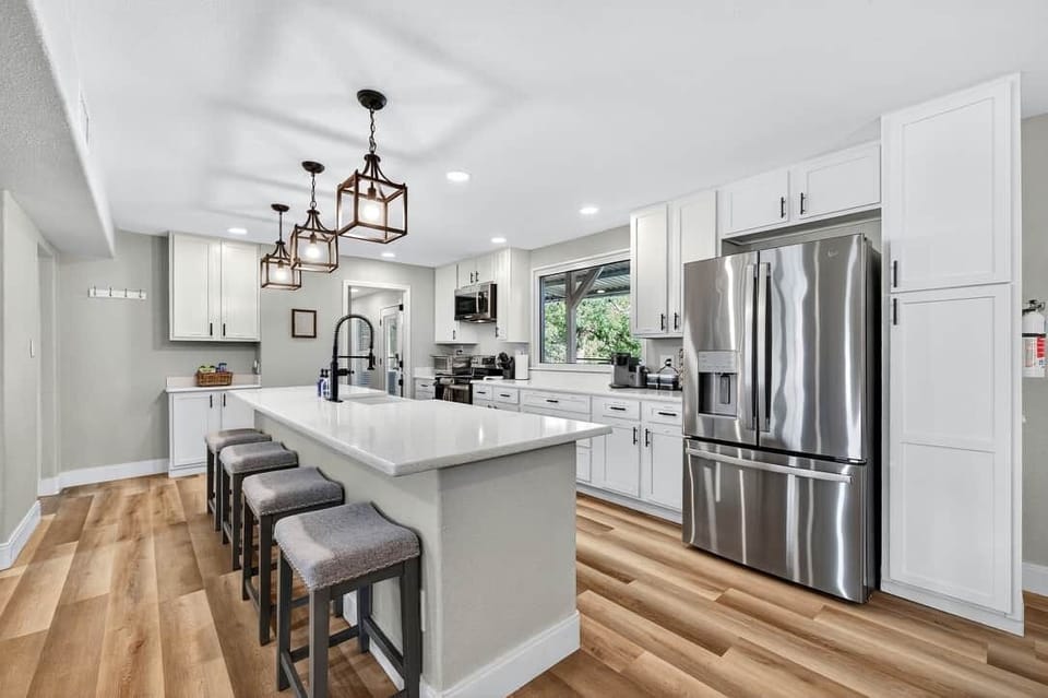 Spacious kitchen with large island and stainless steel appliances.