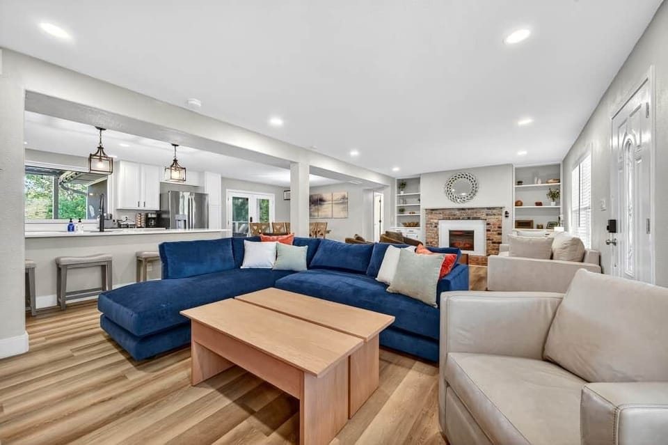 Open living room with seating, connected to the kitchen and dining area.