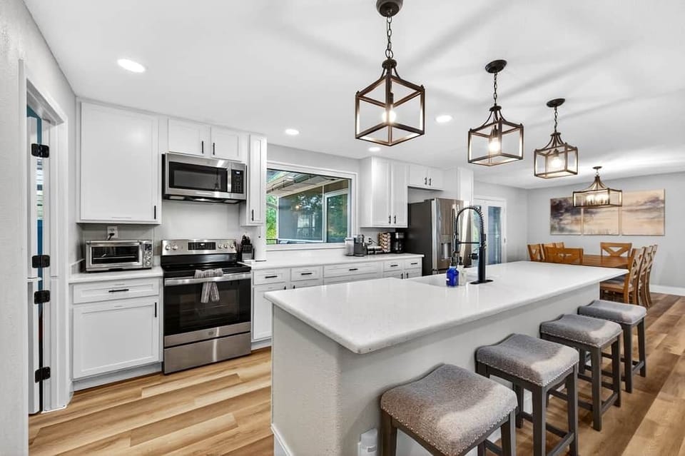 Open kitchen with large island, bar seating, and dining area nearby.
