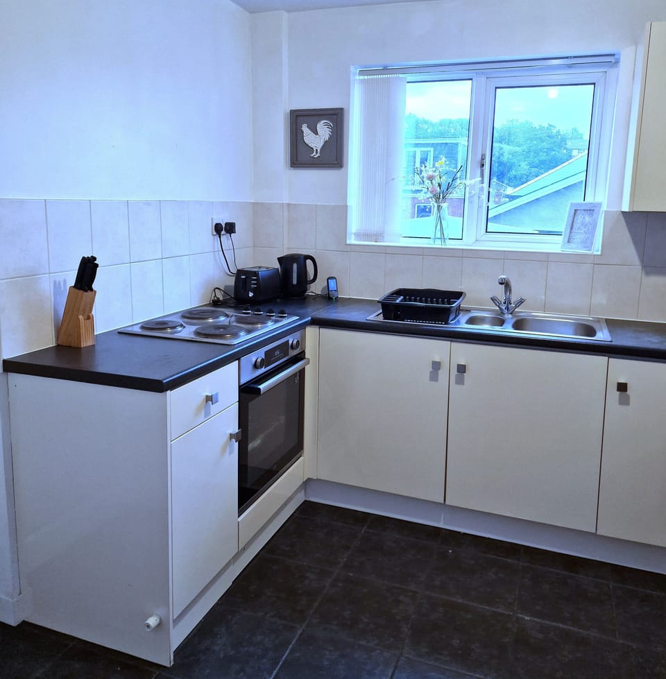 Well-equipped kitchen with oven, kettle, toaster and sink
