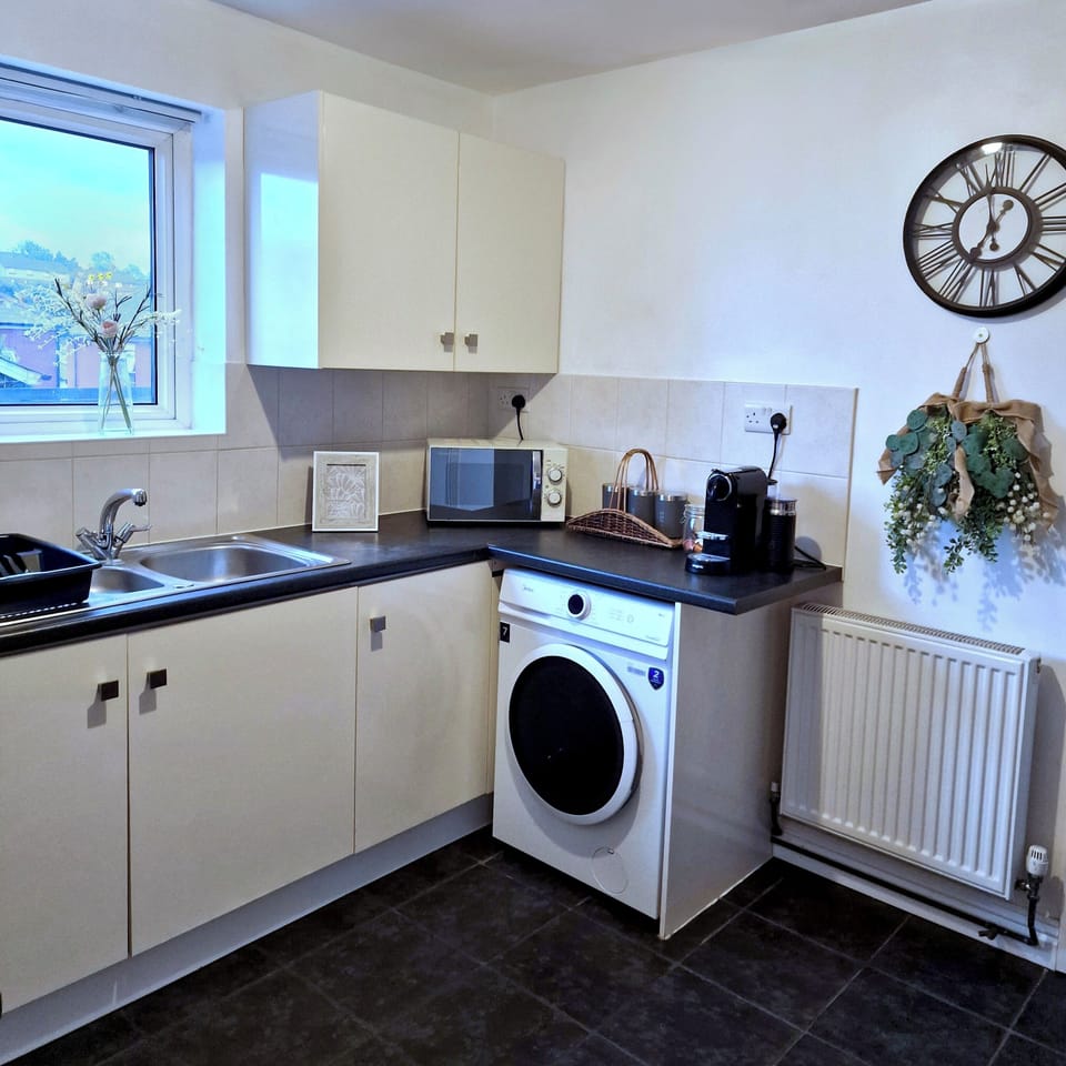 Bright, modern kitchen with microwave, sink and washer