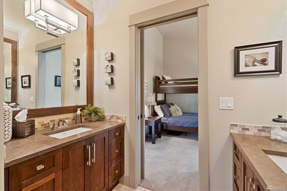 Upstairs Jack and Jill bathroom featuring a double vanity and walk-in shower.
