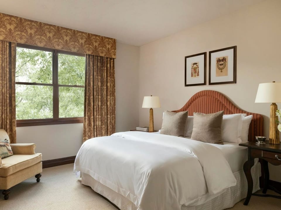 Unwind in a serene bedroom with leafy views and plush bedding.