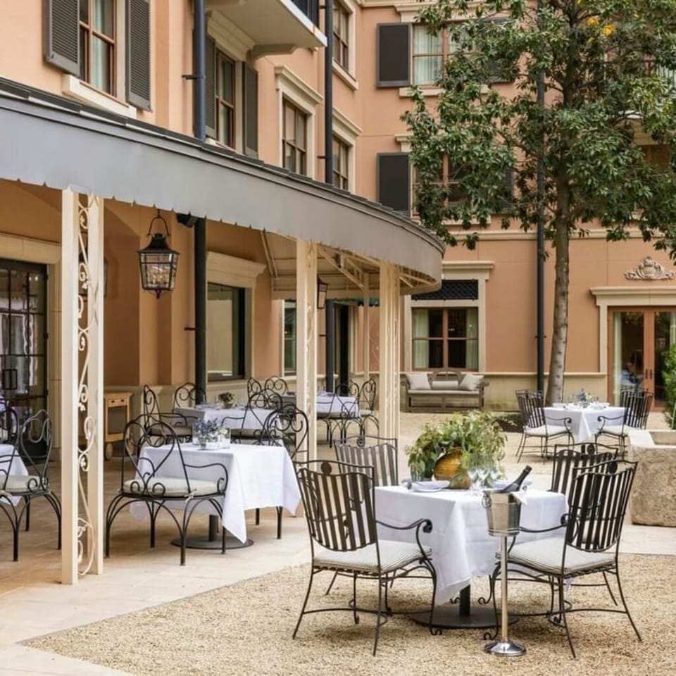 Dine alfresco under the arcade with crisp linens and fresh air.