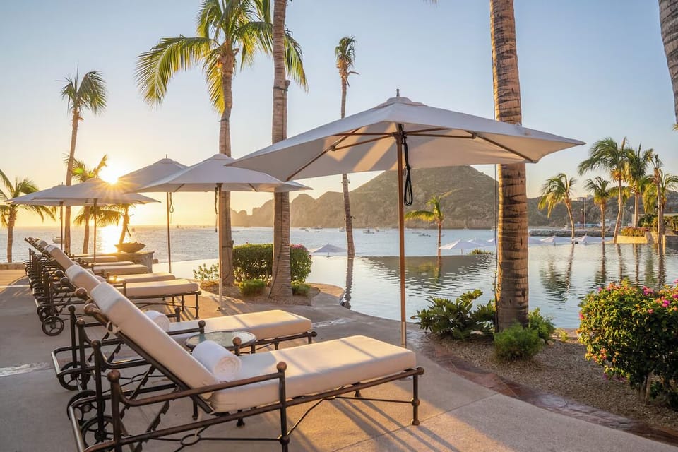 Lounge at sunrise beside calm waters and swaying palms
