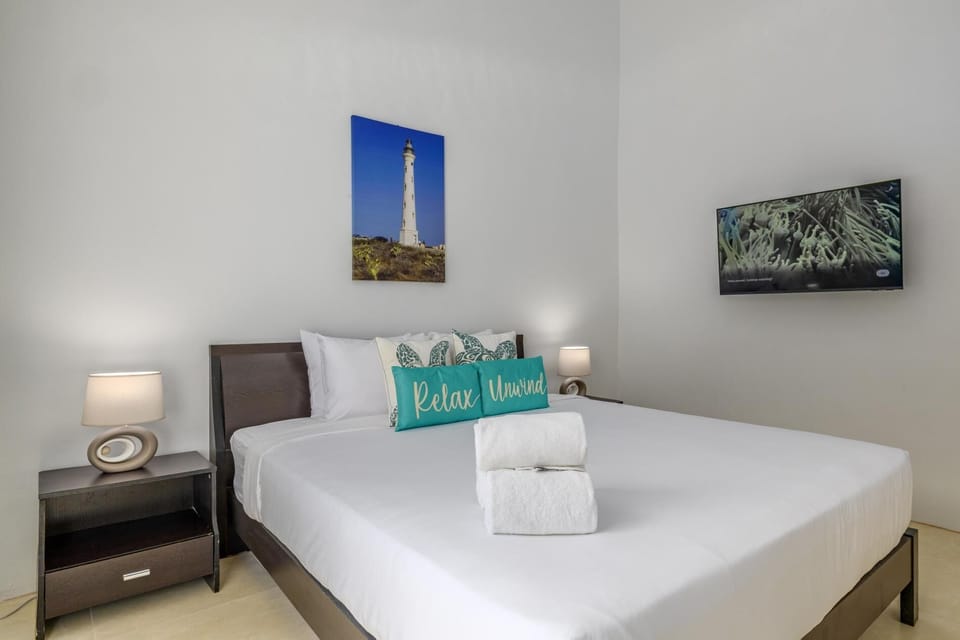 A serene primary suite featuring a king-size bed, Smart TV, private ensuite bath, and in-room safe! your peaceful retreat after sun-filled island days.