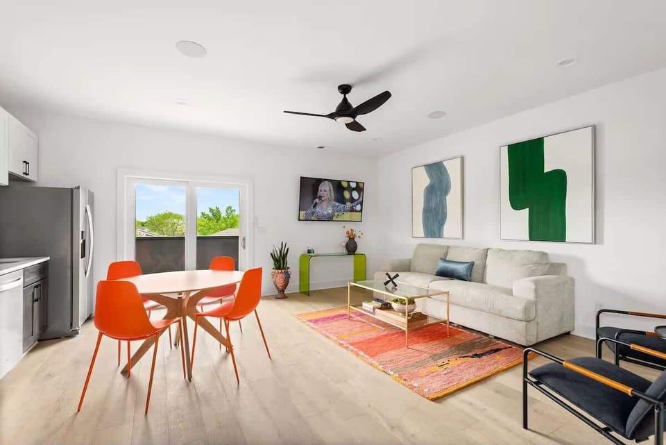 Second living area with vibrant accents, comfortable seating, a Smart TV, and a fully equipped kitchen in view, creating an easy flow for relaxing, dining, and gathering. (3rd Floor)