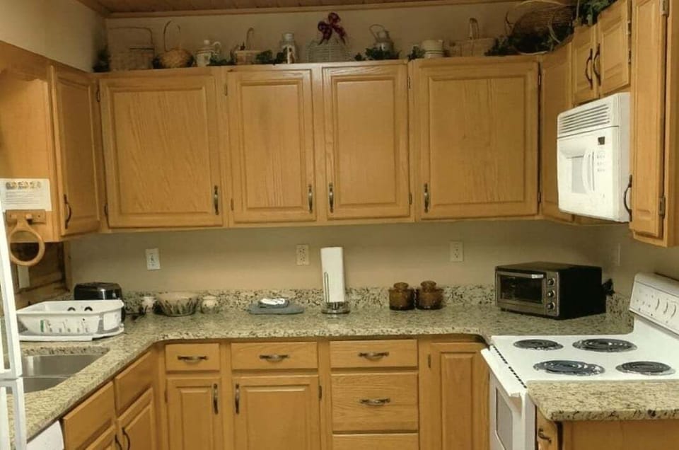 Fully equipped kitchen with electric stove, dishwasher, microwave, toaster, and coffee maker at A Windy Ridge cabin in Wears Valley, Tennessee.