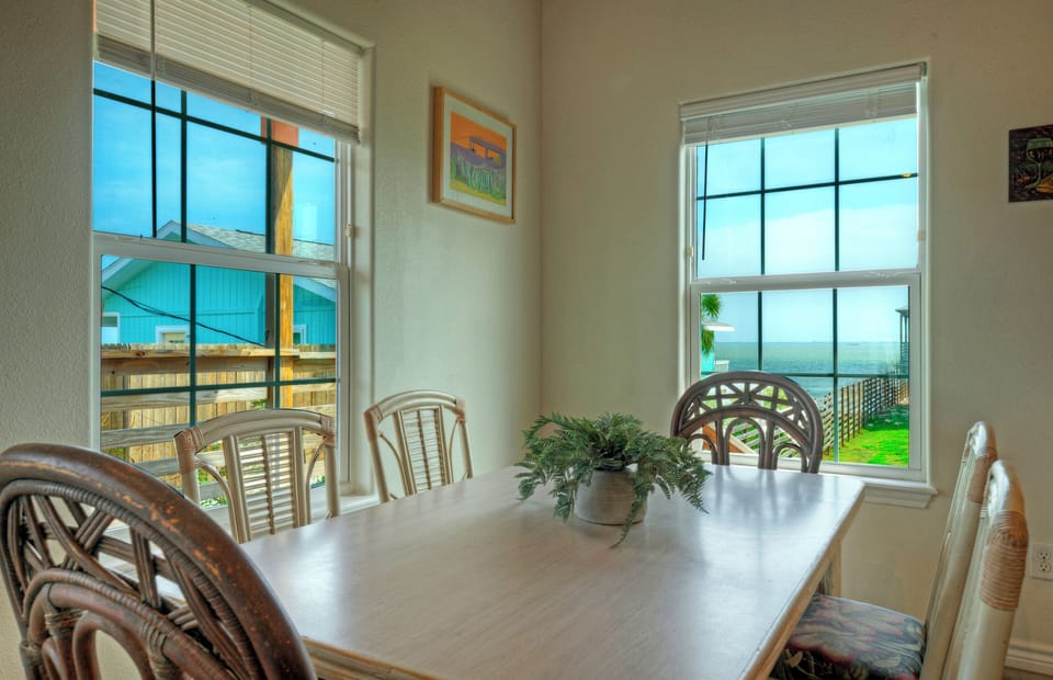 Gather for meals in the sunny dining nook, with a full kitchen and breakfast bar under warm, vaulted wood ceilings.