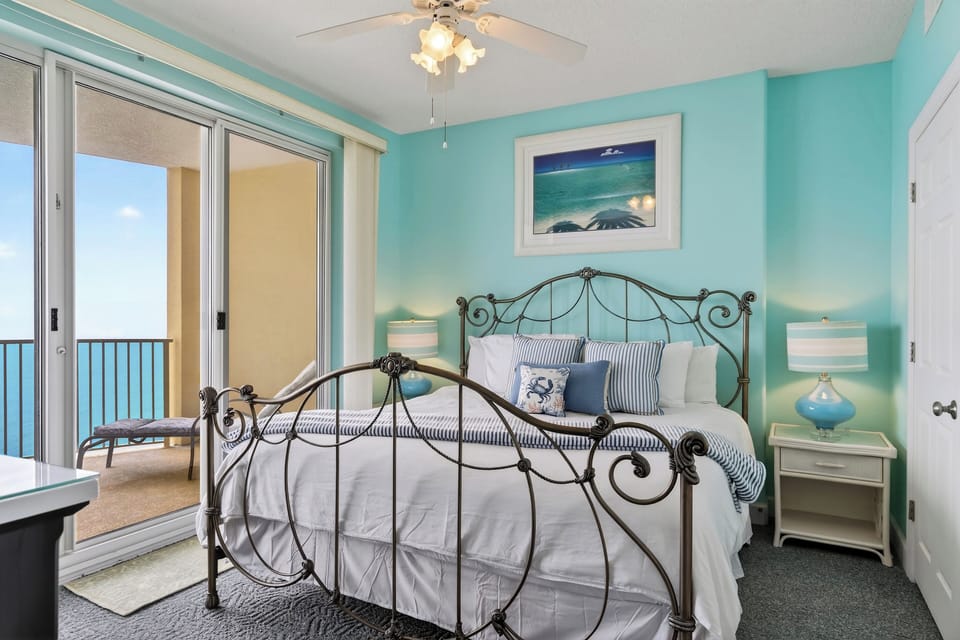 The primary bedroom features a king bed, a TV, and balcony access.