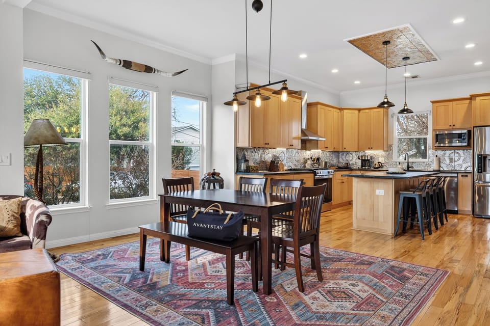 Bright, open kitchen and dining setup with island seating—perfect for meals, games, and easy hosting.
