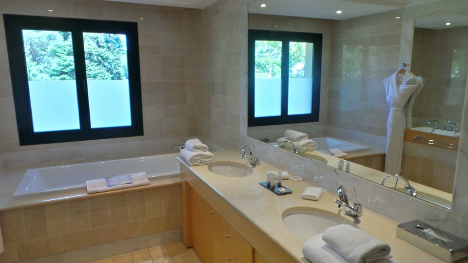 Separate tub and shower, rainfall showerhead, designer toiletries