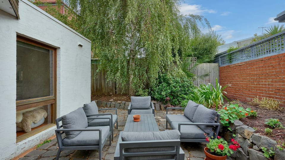 Sunny patio surrounded by greenery — perfect for morning coffee