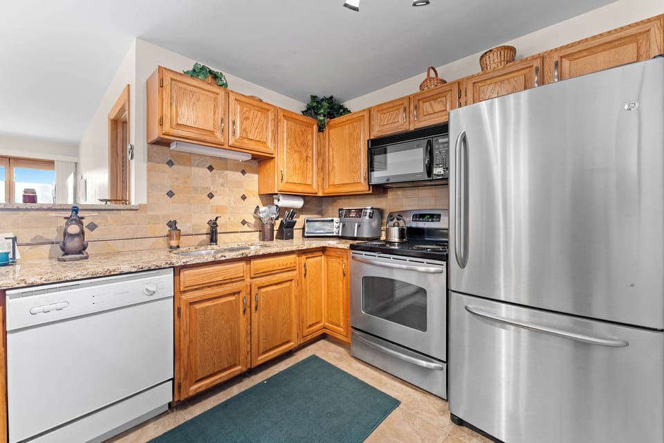 Your fully equipped kitchen features granite counters, stainless steel appliances, and warm wood cabinets for delicious home-cooked meals.