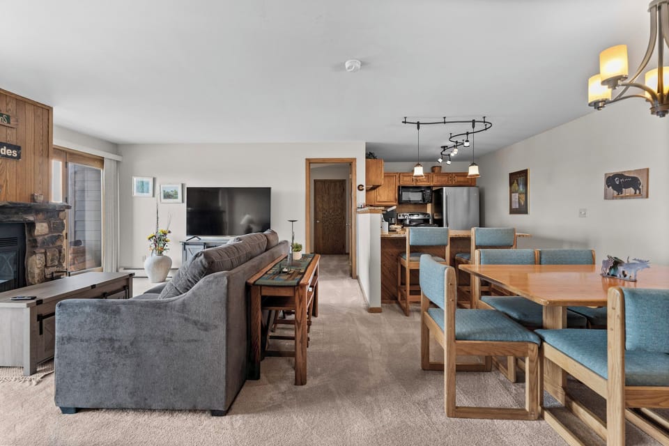 Gather around the spacious open-plan living and dining area, where rustic wood accents and modern comfort blend seamlessly for your mountain getaway.