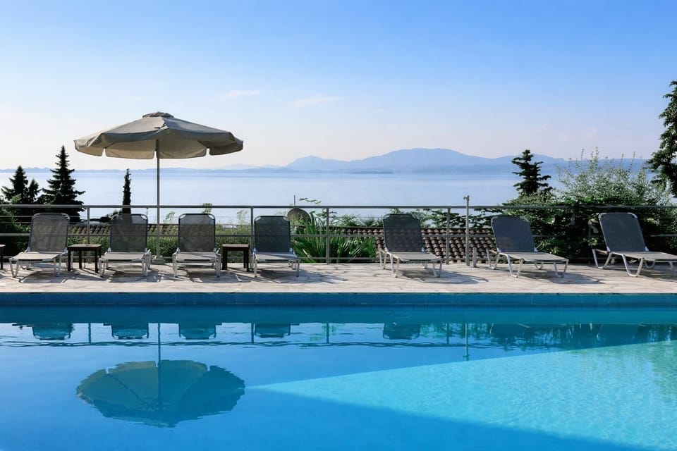 Relax by the pool on comfortable sun loungers while enjoying beautiful views of the Ionian Sea and surrounding coastal landscape.