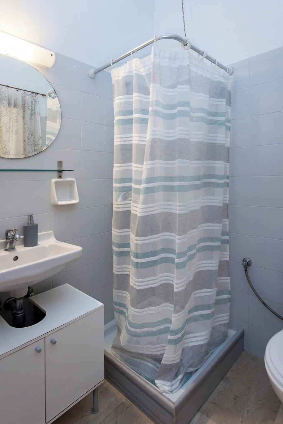 
Well-lit bathroom with modern fixtures and a refreshing shower space for your daily routine.