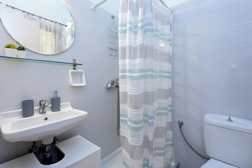 Clean and practical bathroom with shower, sink, and essential amenities to ensure a comfortable stay.