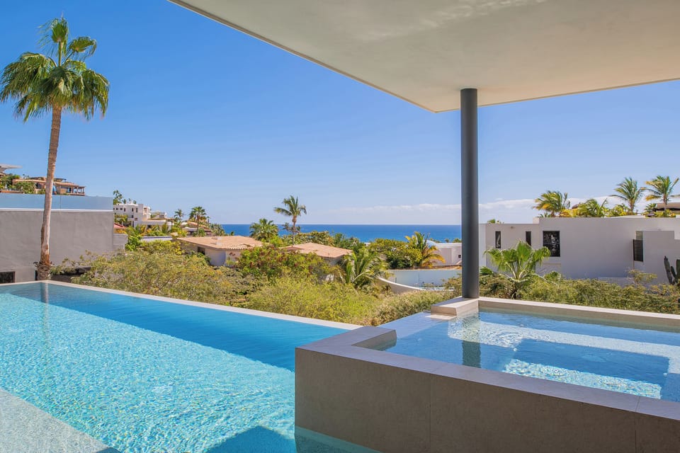 Your private infinity pool offers stunning ocean views framed by swaying palms and tropical gardens—pure paradise awaits.