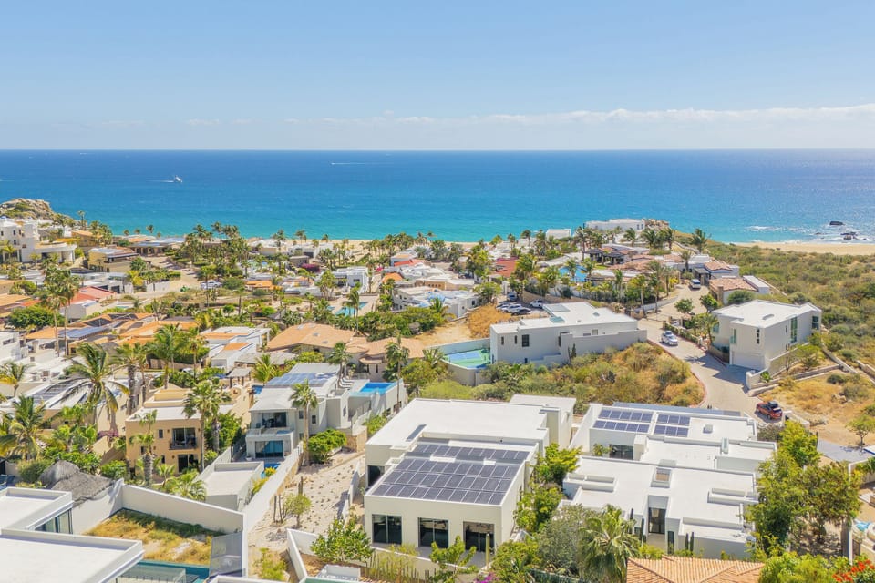 Stunning aerial view of beachfront community with turquoise waters and pristine coastline nearby.