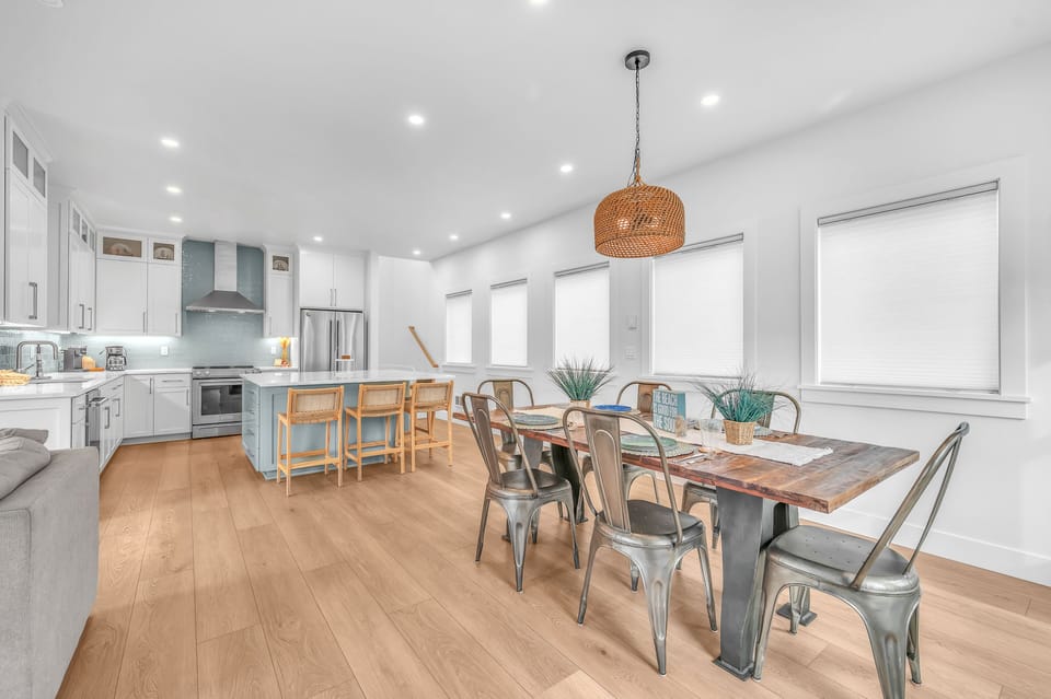 Your open-concept kitchen and dining space blends modern comfort with industrial charm, perfect for gathering around the rustic wood table after cooking.