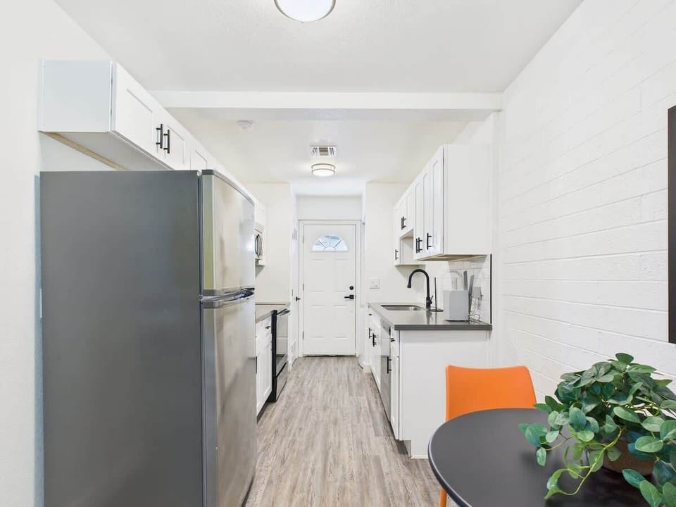Fully equipped kitchen stocked with basic cooking essentials, stainless steel appliances, access to the shared backyard, and a washer and dryer.