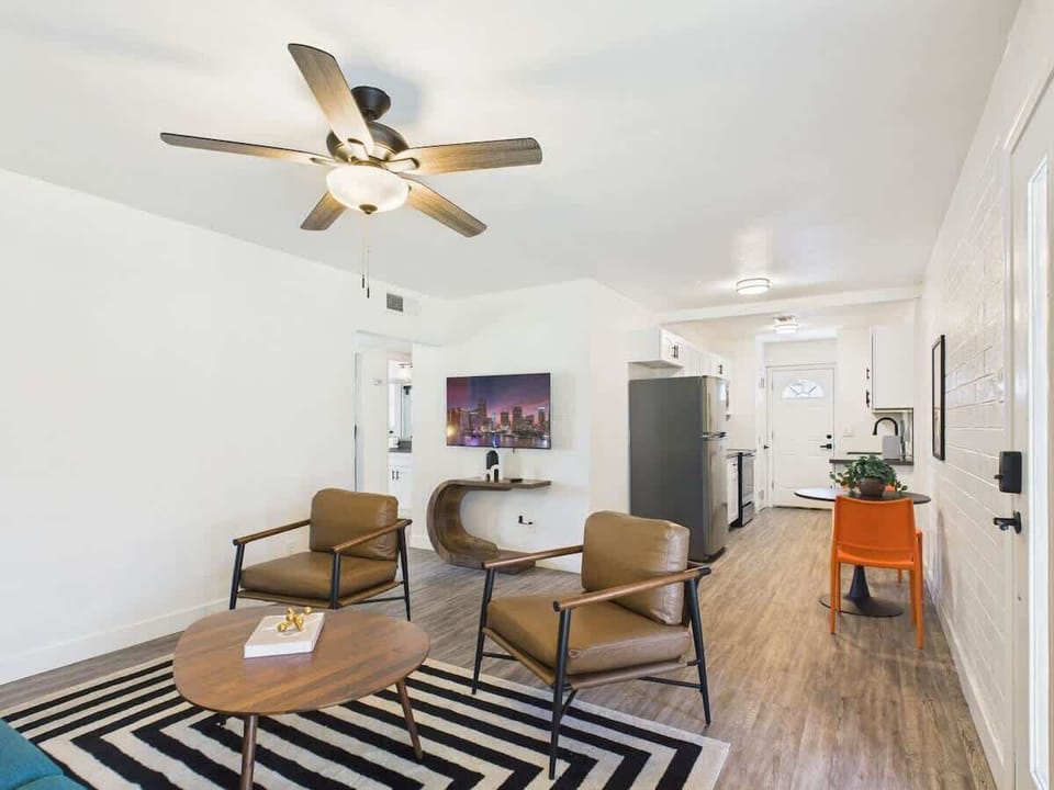 Bright and open living area featuring a smart TV, designer furnishings, and a dining table that seats 2 guests.