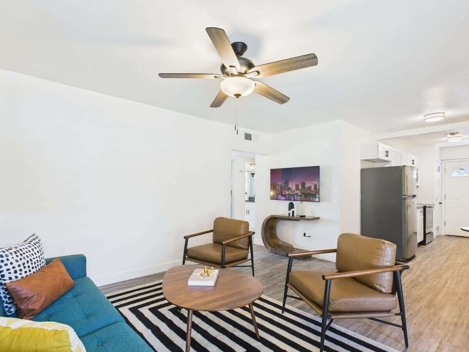 Bright and open living area featuring a smart TV, designer furnishings, and a dining table that seats 2 guests.