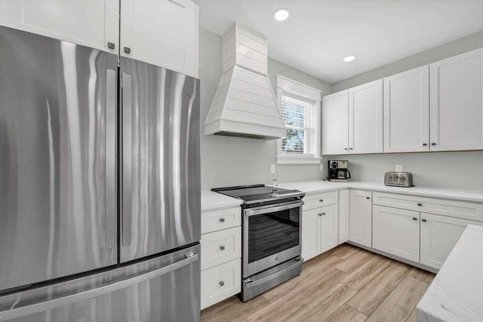 Stainless Appliances, gleaming Quartz Countertops, and beachy white Cabinetry.