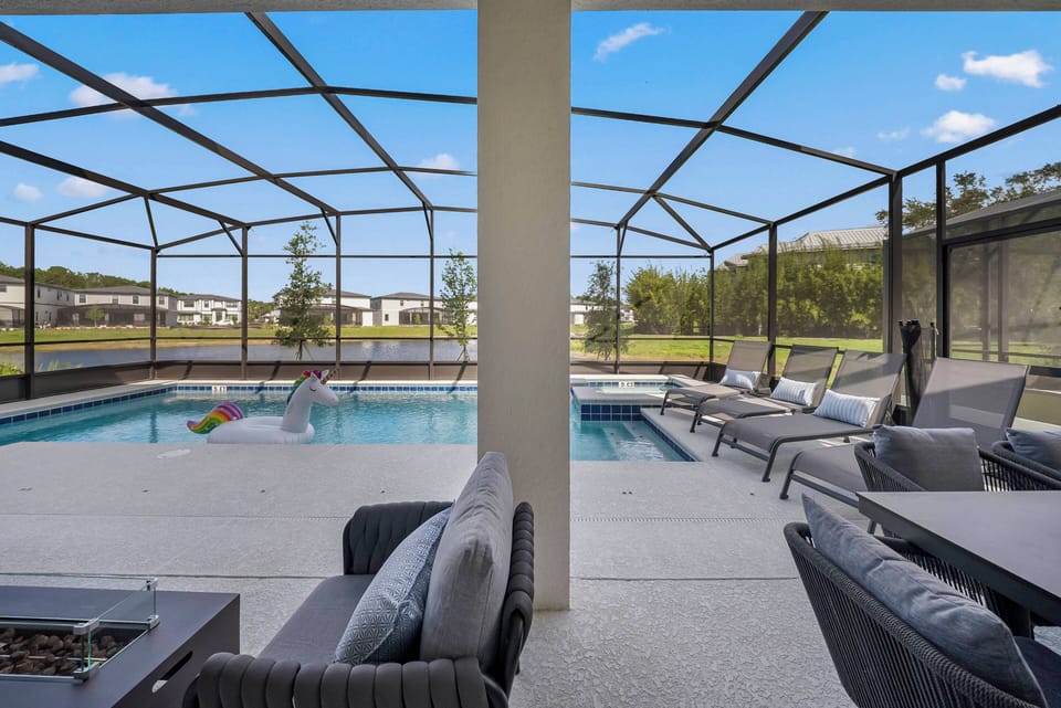 Discover your private paradise with sleek gray seating by a sparkling pool, inviting you to relax under a clear blue sky. The spacious lanai is ideal for lounging or enjoying meals, combining indoor comfort with outdoor serenity.