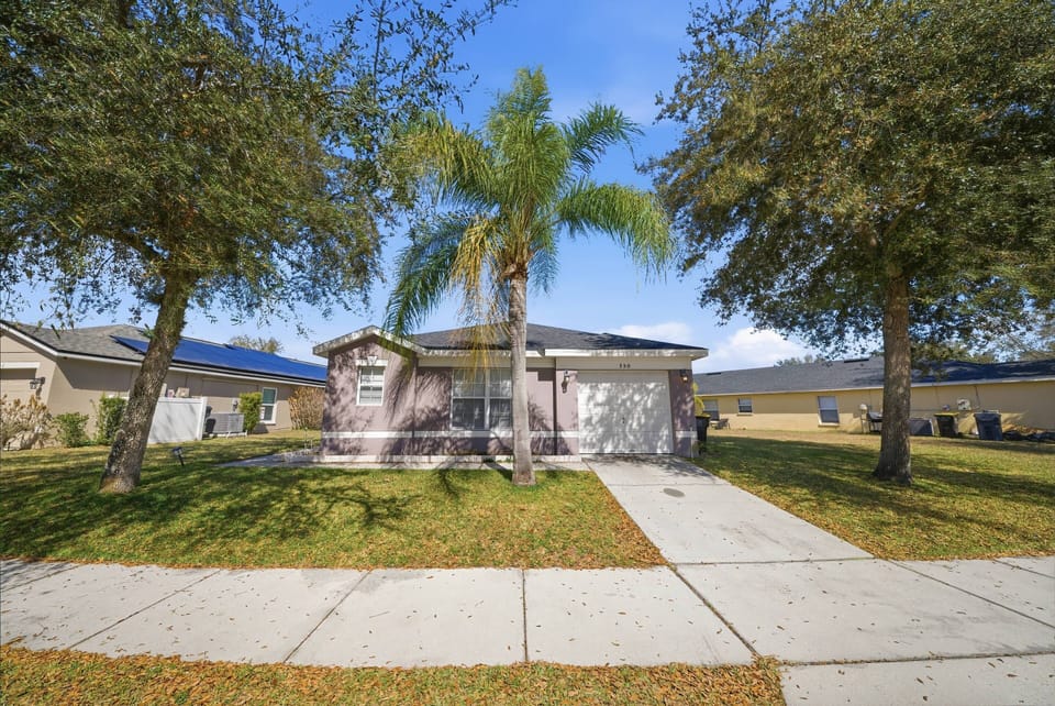 Step into a sunlit exterior framed by graceful palm trees, creating a welcoming atmosphere. The charming facade features a blend of warm colors and inviting textures, perfect for enjoying your morning coffee or evening relaxation.