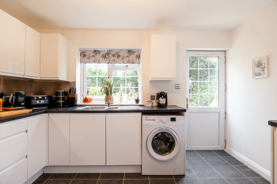 Kitchen with washing machine and back door access to the garden