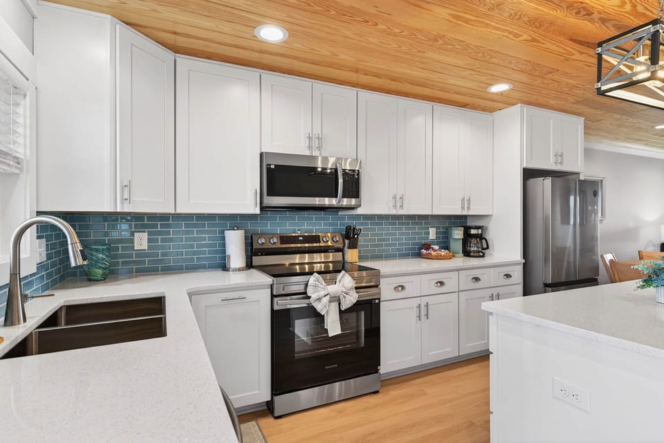 Chef's dream! Modern kitchen with a teal subway tile backsplash and crisp white.