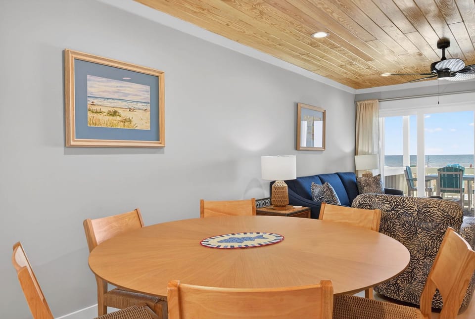 A round wooden dining table perfect for family meals and beachy vibes.