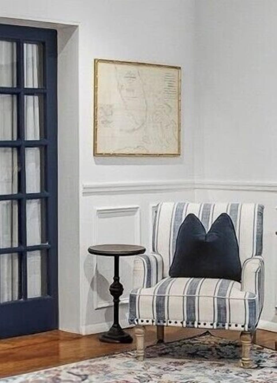 Sink into your cozy striped armchair with morning coffee, surrounded by elegant wainscoting and thoughtful nautical touches.