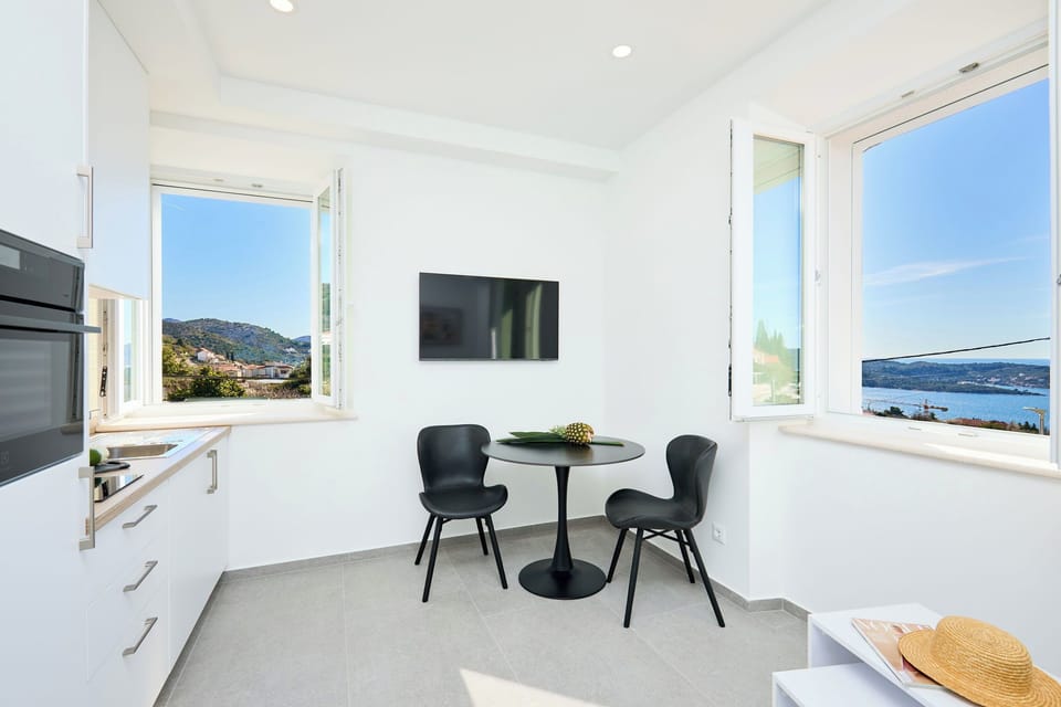 Enjoy breakfast with breathtaking sea and mountain views from this bright, modern kitchenette and dining area.