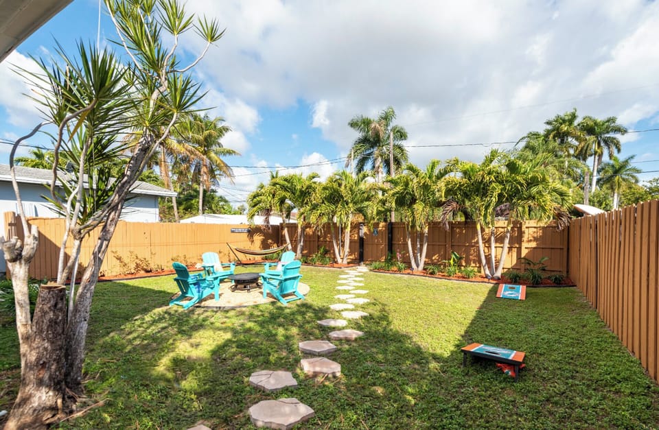 Tropical oasis backyard with fire pit, hammock, cornhole & grill. Fully fenced.