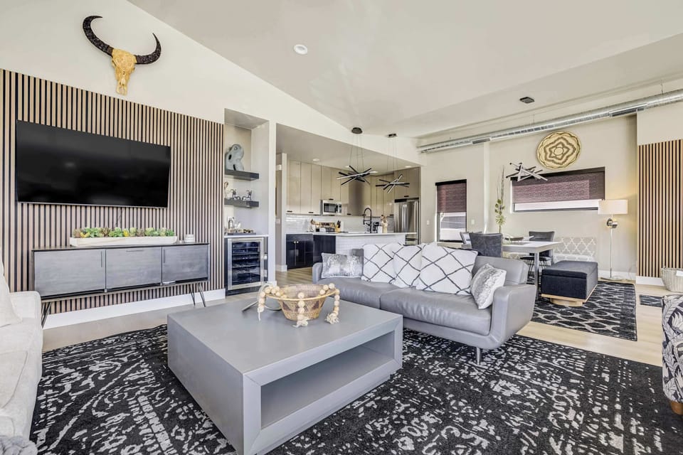 This sophisticated social center is a masterclass in intentional design, featuring plush designer seating and a minimalist coffee table. A floor-to-ceiling wood slat feature wall provides a warm, architectural backdrop for the home.