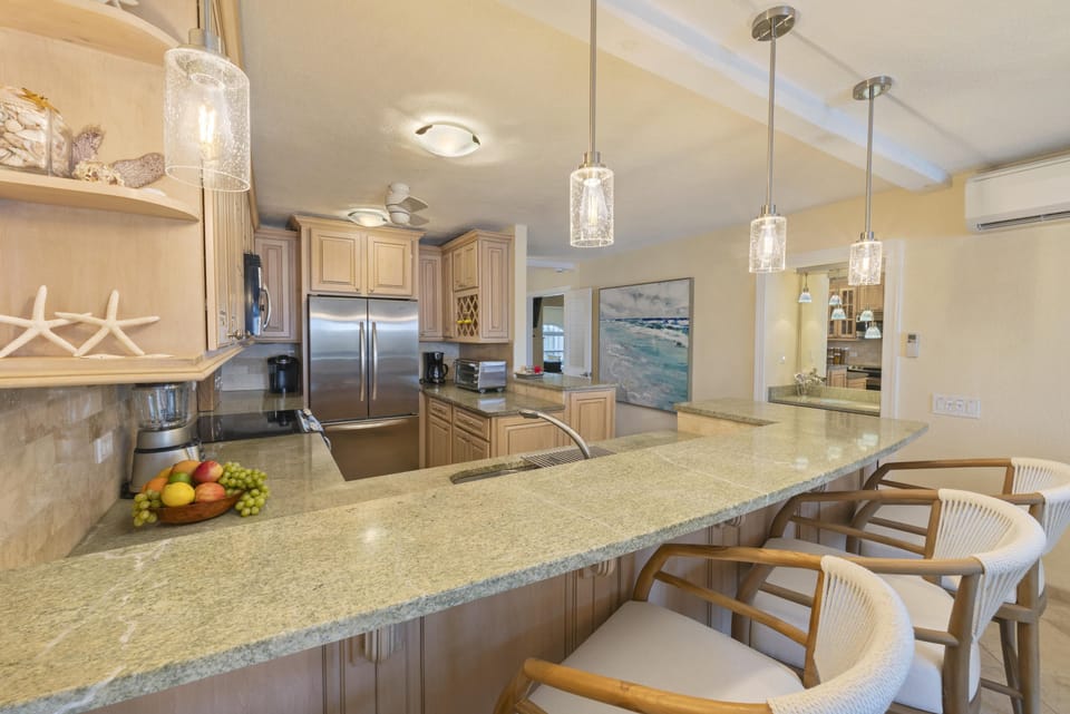 Granite breakfast bar with four comfortable stools with backs.