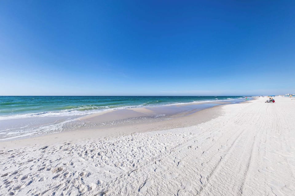 {BEACH} Soft white sand and clear Gulf waters just steps away—your Orange Beach escape starts here