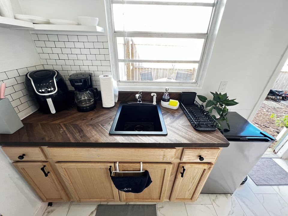 Kitchen counter with sink, coffee machine, dish rack & mini fridge