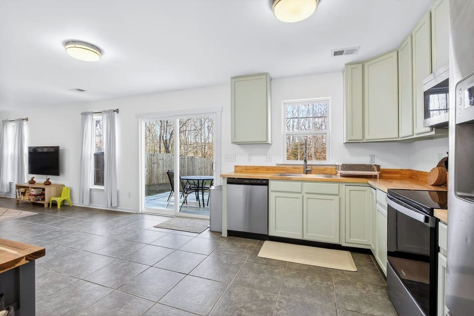 Bright open space connecting the kitchen, living room, and outdoor patio.