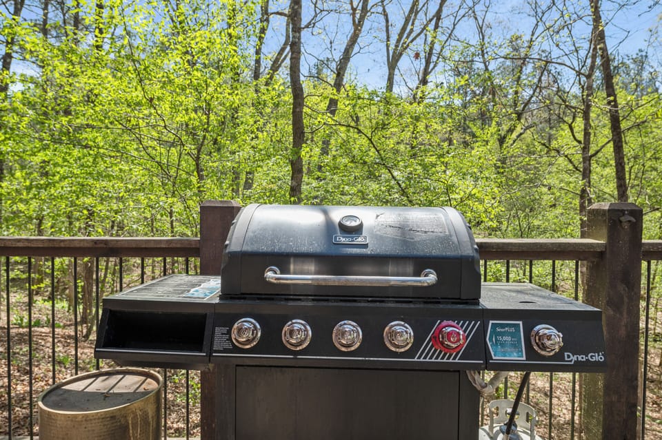 Private deck with grill and forest views for relaxing outdoor cookouts.