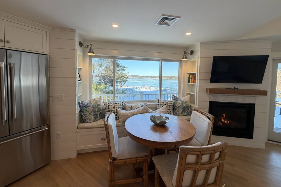 Gorgeous ocean views from the dining area with plenty of seating for the whole family.  Also pictured is a smart TV and gas fireplace.