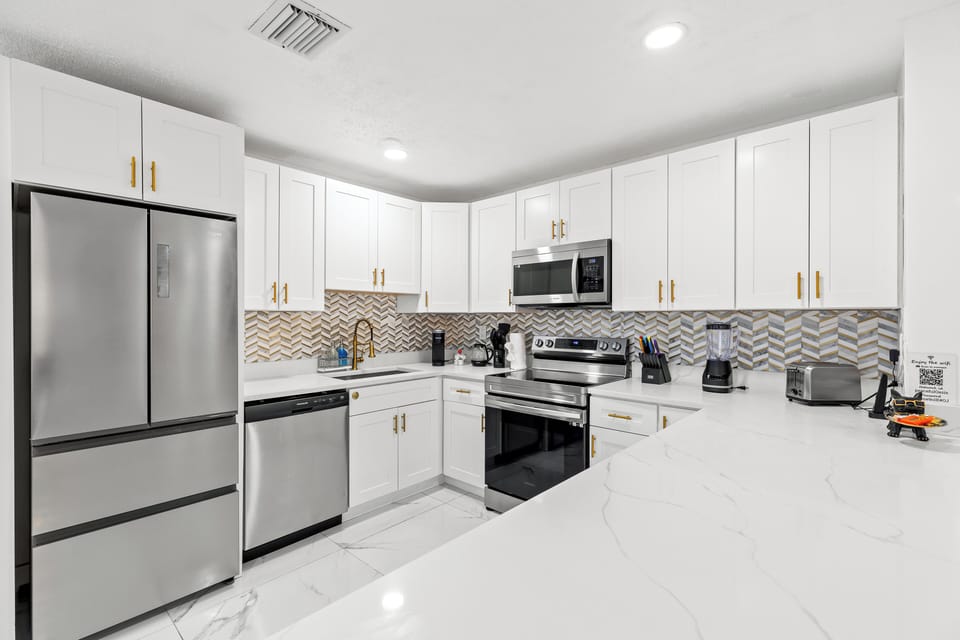 Open kitchen with island seating plus a dedicated workspace—ideal for meals, planning, and remote work.