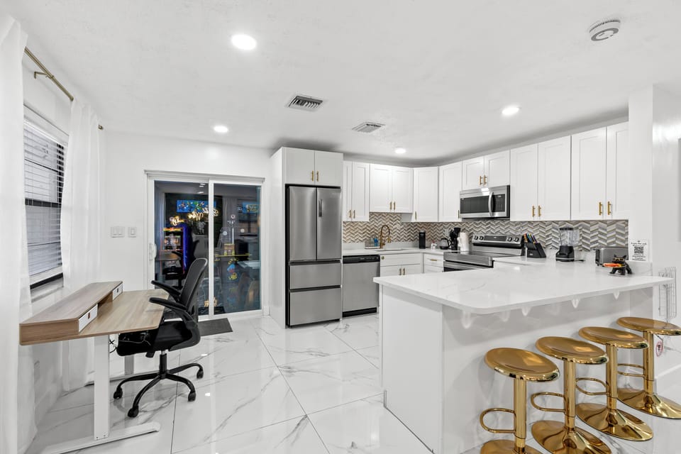 Open kitchen with island seating plus a dedicated workspace—ideal for meals, planning, and remote work.