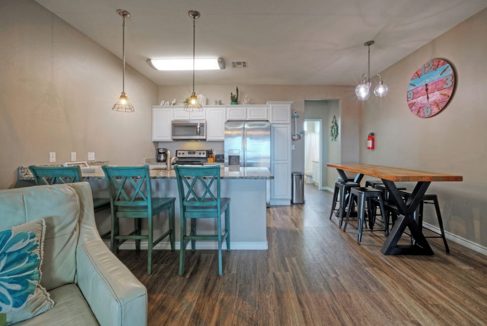 Open-concept kitchen & dining with breakfast bar seating—perfect for group meals and beach-day planning. 